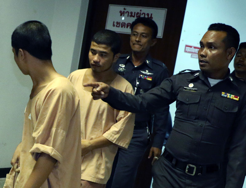 The two Myanmar migrant workers Ko Win Zaw Htun (L) and Ko Zaw Lin Oo (L-2), suspects in the killing of two British tourists, are escorted by police officers as they leave Koh Samui Provincial Court in Surat Thani province, southern Thailand, October 14, 2014. Photo: Sitthipong Charoenjai/EPA