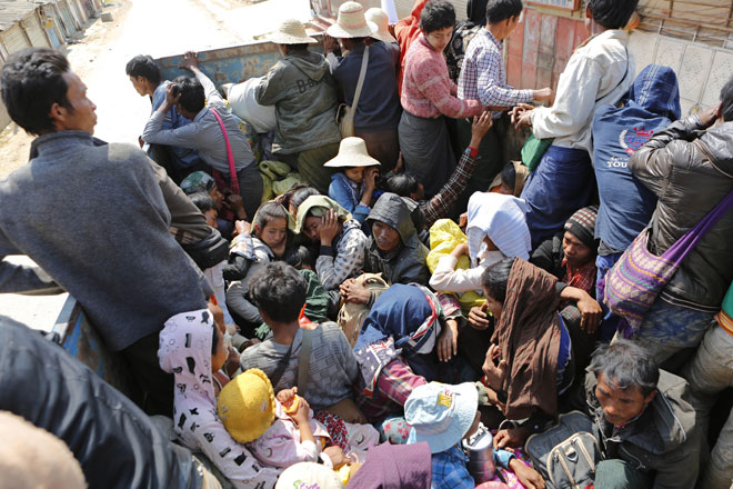 Victims of the conflict sit on board a rescue truck as they flee fighting in the Kokang capital Laukkai, northern Shan State, Myanmar, February 17, 2015. Photo: Lynn Bo Bo/EPA
