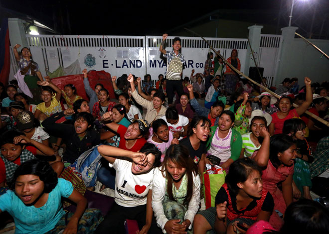 Workers shout slogans as they protest outside their factory after a clash with police at Shwepyithar Industrial zone in Yangon, Myanmar, February 20, 2015. Myanmar police dismantled the protest sites and several people were injured during the clash between protesters and policemen. Thousands of workers are demanding a raise in their basic salary at the industrial zone. Photo: Nyein Chan Naing/EPA