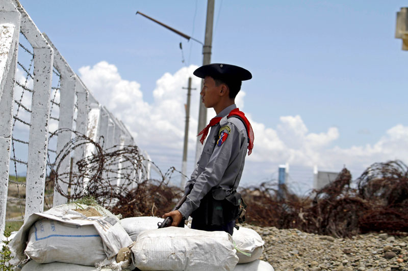 A Myanmar policeman stands guard at the border guard force camp at the Myanmar-Bangladesh border fence in Maungdaw, Rakhine State, Myanmar, June 7, 2014. Photo: Nyunt Win/EPA