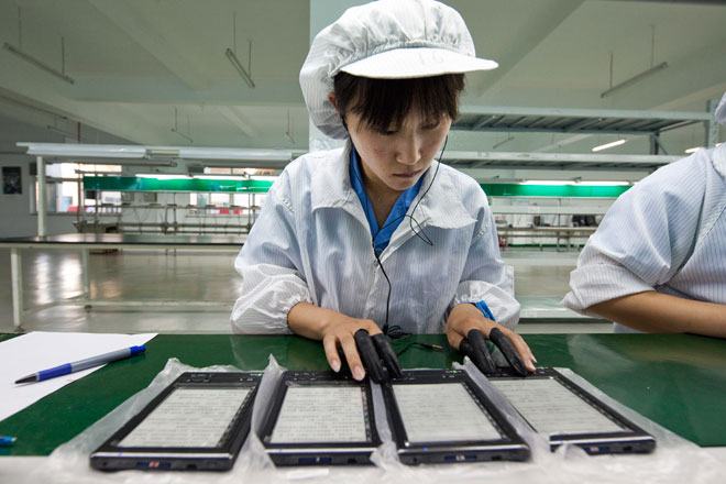 China's economy slowing. Workers at Hanwang Technology assembling electronic books in their factory near Beijing, China. Photo: Adrian Bradshaw/EPA