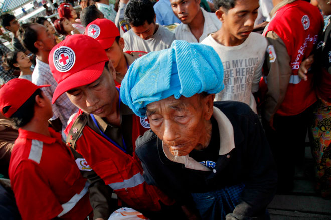 An elderly survivor of the ferry vessel accident is assisted upon arrival at the Sittwe port, Myanmar, March 14, 2015. Photo: Nyunt Win/EPA