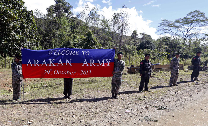 Arakan Army soldiers holding a banner of welcome for the convoy of Ethnic Armed Organizations leaders while on its way from Myitkyina to Laiza, Kachin State, Myanmar, October 29, 2013. Photo: Nyein Chan Naing/EPA