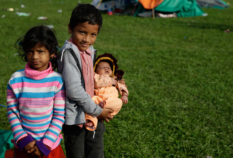 Children near their temporary tent on open ground in Kathmandu after a powerful earthquake followed by strong aftershocks struck Nepal, in Kathmandu, Nepal, April 27, 2015. Photo: Narendra Shrestha/EPA