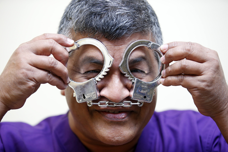 Malaysian political cartoonist Zulkiflee Anwar Haque, or 'Zunar', reacts with mock handcuffs during his case at Duta Court, in Kuala Lumpur, April 3, 2015. Zunar is facing nine charges under Malaysia's Sedition Act which are related to a series of tweets were he criticized the Malaysian judicial system. Photo: Fazry Ismail/EPA