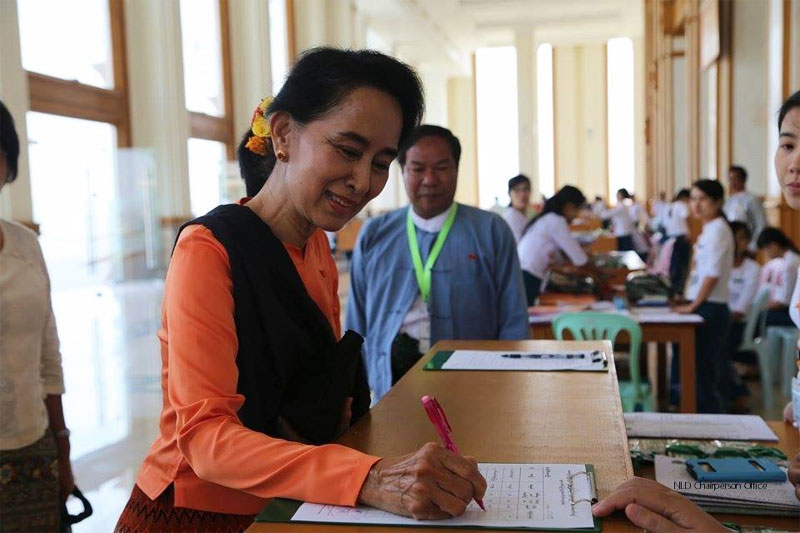 National League for Democracy Chairperson Daw Aung San Suu Kyi signs at Parliament in Nay Pyi Taw on April 2, 2015. Photo: NLD