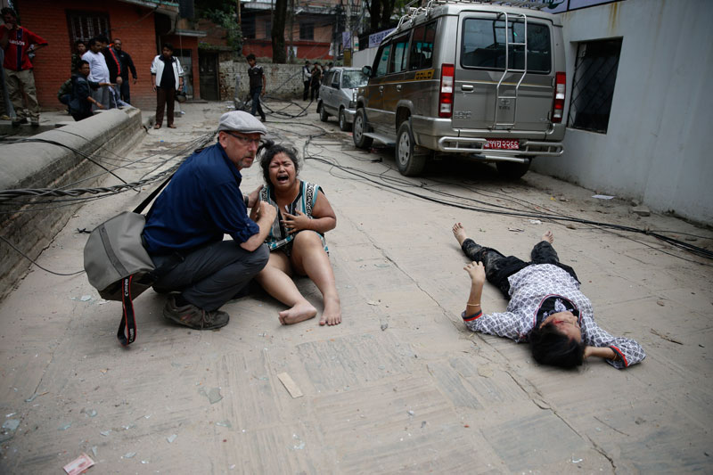 A man comforts a woman next to a seriously injured person on the ground after an earthquake hit Nepal, in Kathmandu, Nepal, 25 April 2015. A 7.9-magnitude earthquake rocked Nepal destroying buildings in Kathmandu and surrounding areas, with unconfirmed rumours of casualties. Photo: Narendra Shrestra/EPA