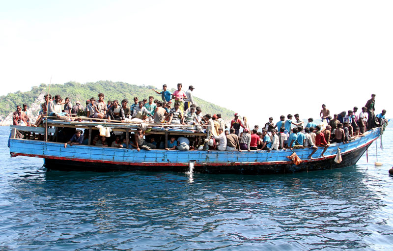Rohingya refugees from Myanmar gather on a boat as they are being rescued by Thai Navy officers before they head to Malaysia, at the Andaman coast, Phuket island, southern Thailand, January 29, 2013. Photo: Yongyot Pruksarak/EPA