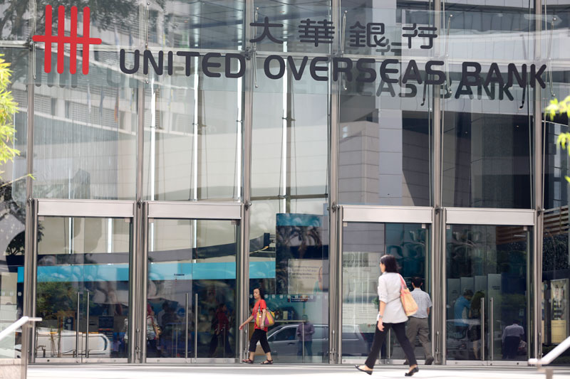 Pedestrians walk past a branch of a United Overseas Bank (UOB) in Singapore, 18 June 2013. Photo: Sam Chin/EPA