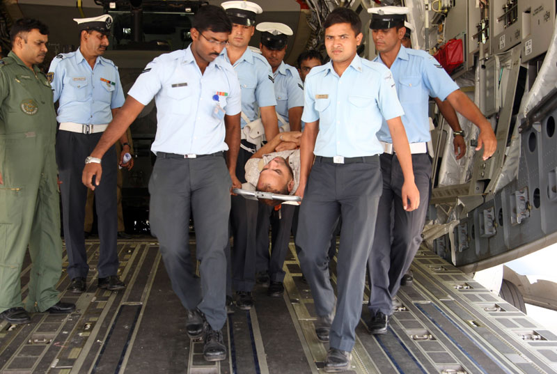 Indian Air Force personnel carrying an injured person flown by an IAF aircraft from earthquake hit Nepal at Air Force Station, Palam, New Delhi, India, May 1, 2015. Photo: EPA