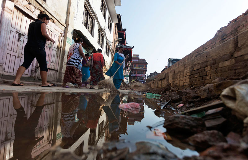 Workers clean a road near a damaged temple in Basantapur Darabar Square in Kathmandu, Nepal, 26 May 2015.