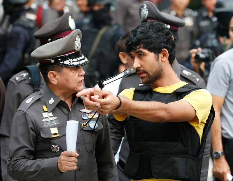 An Erawan Shrine bombing suspect, identified by Thai police as Yusufu Mieraili (R) who was arrested holding a Chinese passport, during a crime reenactment outside a shopping center opposite of the Erawan Shrine in Bangkok, Thailand, 09 September 2015. Photo: Rungroj Yongrit/EPA
