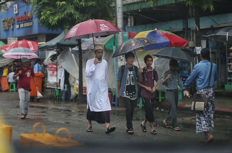 A Muslim man walks on a busy street in downtown Yangon. (Photo: Khun Lat, Myanmar Now)