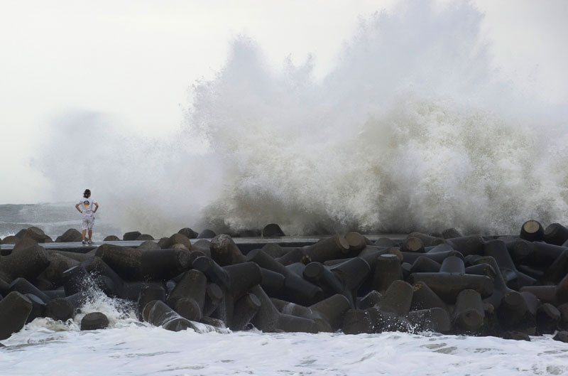 A Japanese surfer watches high waves from Typhoon Etau hit a breakwater in Isumi city, Chiba prefecture, Japan, 09 September 2015. Photo: Everett Kennedy Brown/EPA