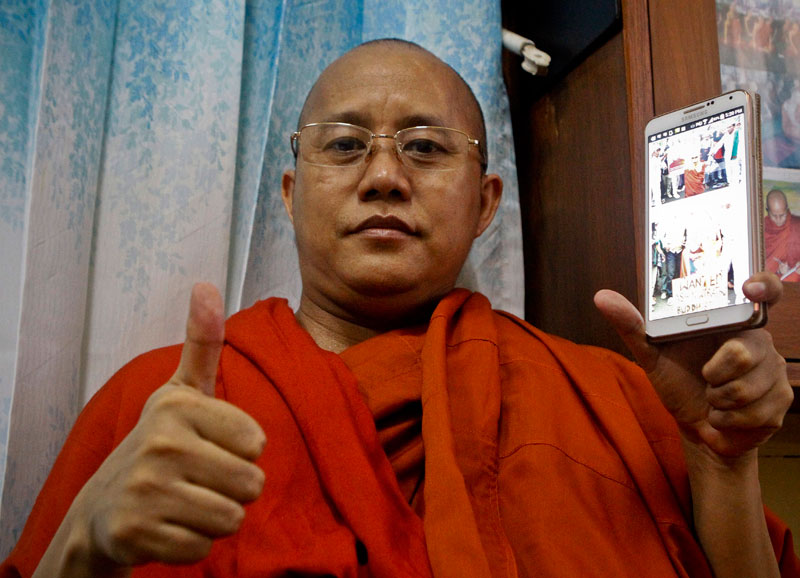 U Wirathu, holds a mobile phone while posing for photos at Masoyein monastery in Mandalay, Myanmar, 29 May 2015. Photo: Pyae Sone Aung/EPA