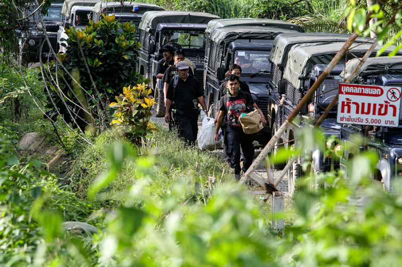 Royal Malaysia Policemen in plain clothes, carry a bag of human remains at Wang Kelian, Perlis, Malaysia, 07 June 2015. Photo: EPA