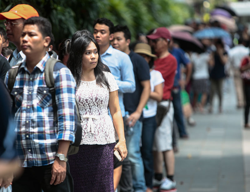 Myanmar expats wait in line to cast their vote outside the Myanmar Embassy building in Singapore, 15 October 2015.