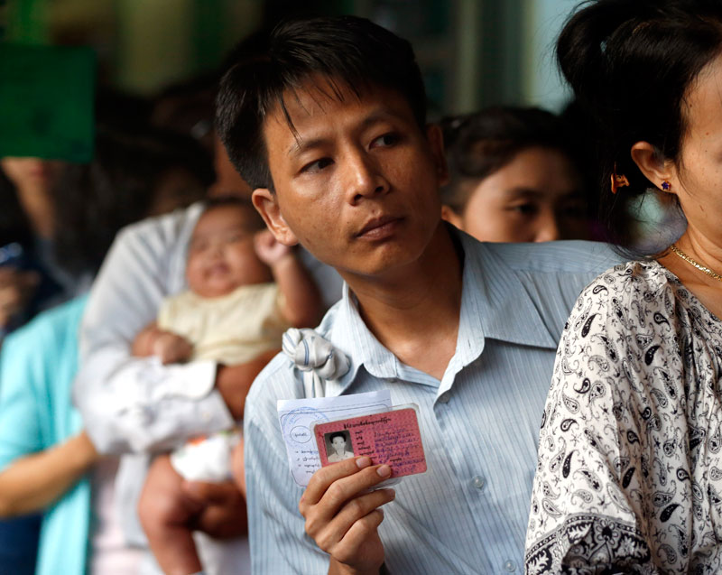 A Myanmar voter holds his citizen ID card while lining up to cast his ballot at a polling station in Yangon, Myanmar, 08 November 2015. Photo: Rungroj Yongrit/EPA
