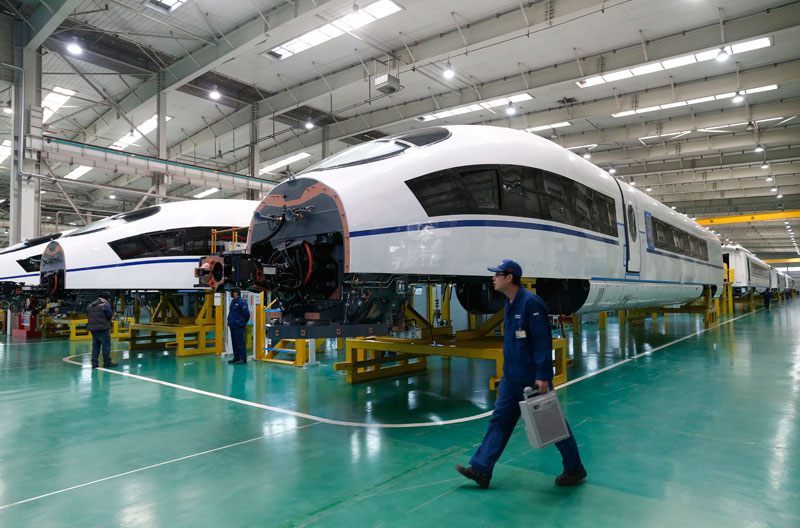 A worker walks past almost completed train cars at an assembly plant of the Tangshan Railway Vehicle Co. Ltd. (TRC) which is a subsidiary of the China Northern Locomotive and Rolling Stock Industry Corporation (CNR), in Tangshan City of Hebei province, China. Photo:Rolex Dela Pena/EPA