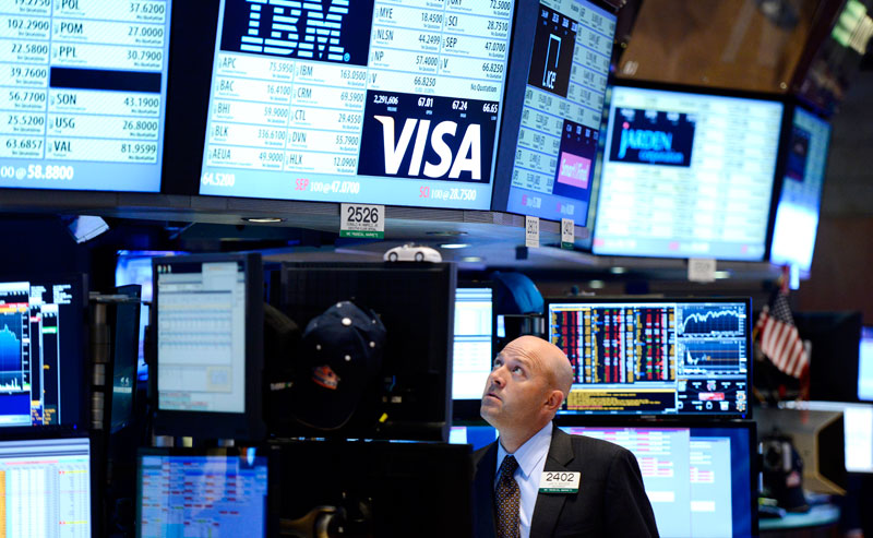 A trader looks up at displays showing halted trading of stocks at the New York Stock Exchange after trading was halted due to a technical glitch in New York, New York, USA. Photo: EPA