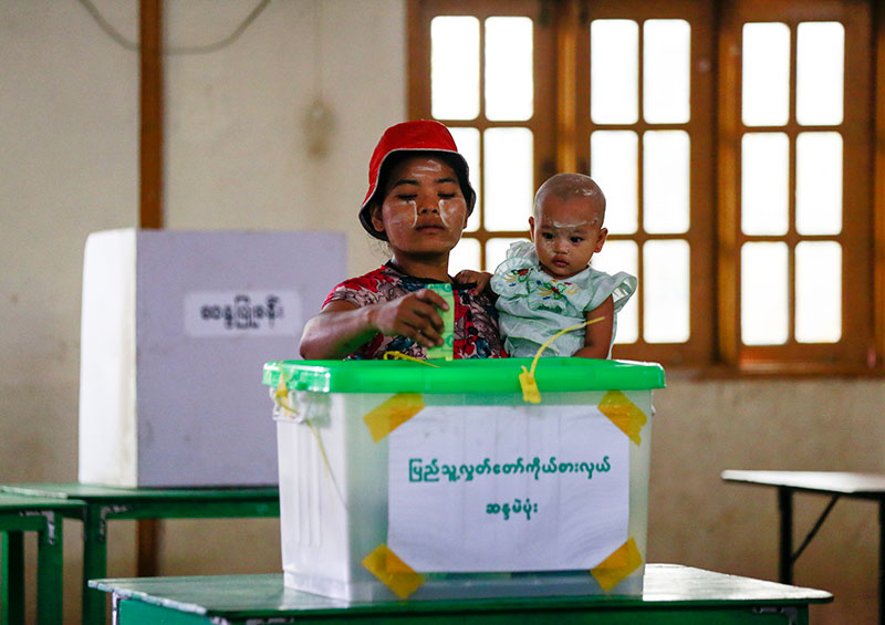 A woman carries her child as she casts her vote for by-elections at a polling station of Hlaing Thar Yar township in Yangon, Myanmar, 01 April 2017. Photo: Lynn Bo Bo/EPA