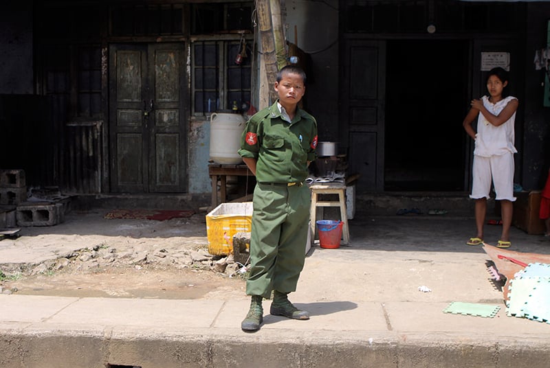 A file photo of a child soldier standing on a platform as a convoy carrying journalists and diplomats visit the Myanmar-China border town Laukkai, Myanmar on 8 September 2009. Photo: EPA
