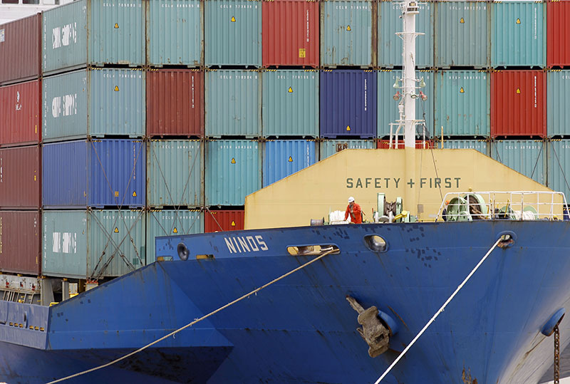 A worker working on a cargo ship loading containers at Asia World port in Yangon. Photo: Lynn Bo Bo/EPA