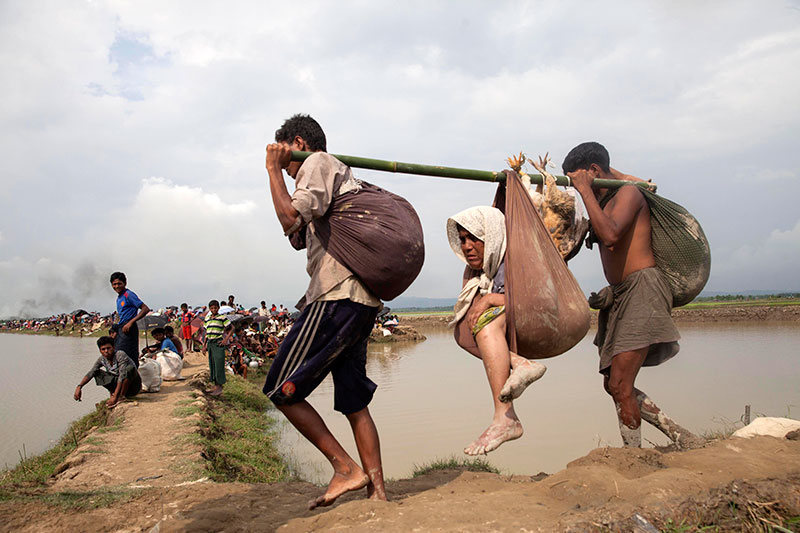 Refugees assist an elderly woman as they enter Bangladesh near the Bangladesh-Myanmar border in Teknaf, Bangladesh, 4 September 2017. Photo: EPA