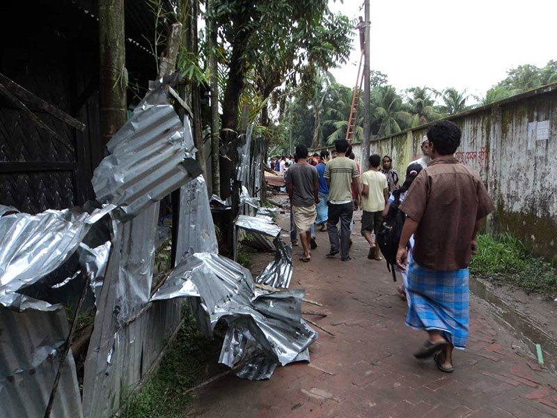 People walk past the ransacked homes of Buddhists in Ramu, some 350 kilometres (216 miles) southeast of the capital Dhaka on September 30, 2012. Thousands of rioters torched Buddhist temples and homes in southeastern Bangladesh Sunday over a photo posted on Facebook deemed offensive to Islam, in a rare attack against the community. Photo: AFP