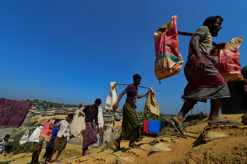 Rohingya Muslim refugees carry bricks to make a road at Kutupalong refugee camp in Bangladesh's Ukhia district on January 23, 2018. Photo: Munir Uz Zaman/AFP