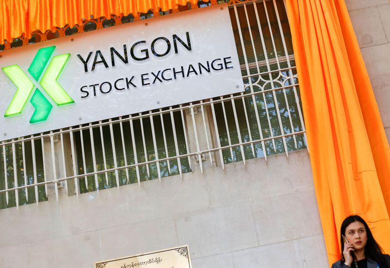YSX to go online - A woman speaks over over mobile phone in front of Yangon Stock Exchange. Photo: Lynn Bo Bo/EPA