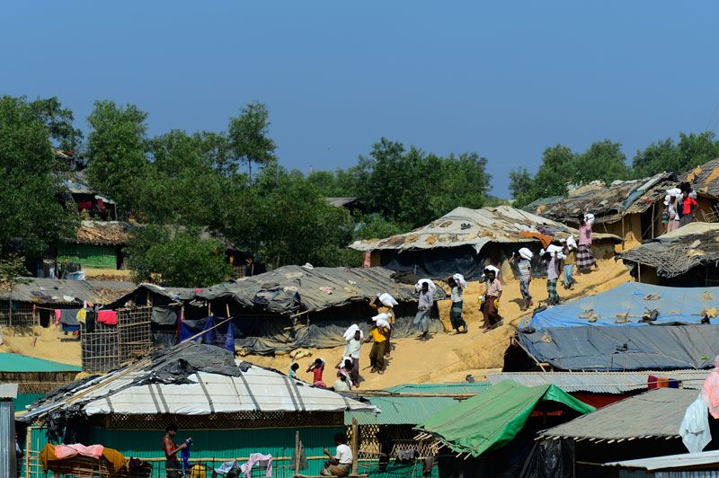 Refugees carry relief materials at Kutupalong refugee camp in Bangladesh's Ukhia district on January 23, 2018. Photo: Munir Uz Zaman/AFP