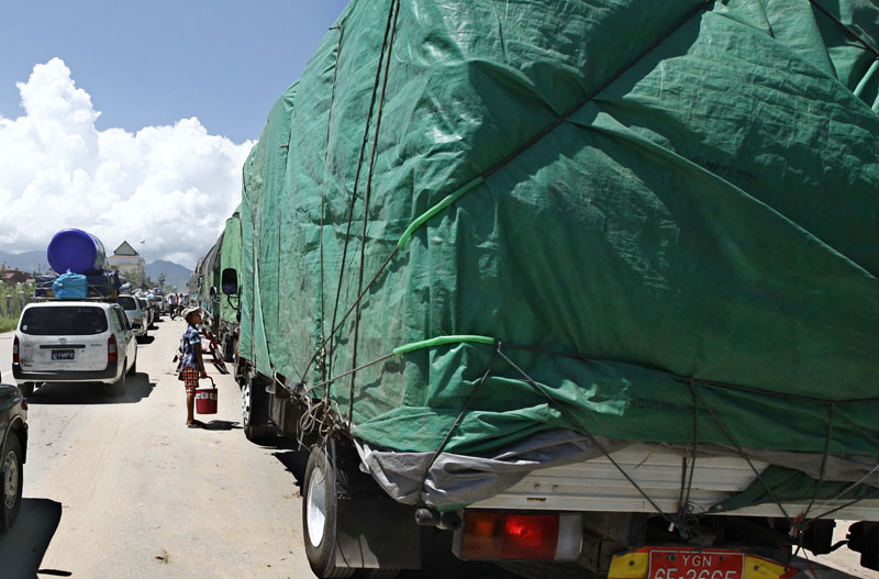 A girl sells water around trucks loaded with goods waiting for check-up near the gate of Myawaddy border trade zone, Myawaddy, Karen State, eastern Myanmar. Photo: Lynn Bo Bo/EPA