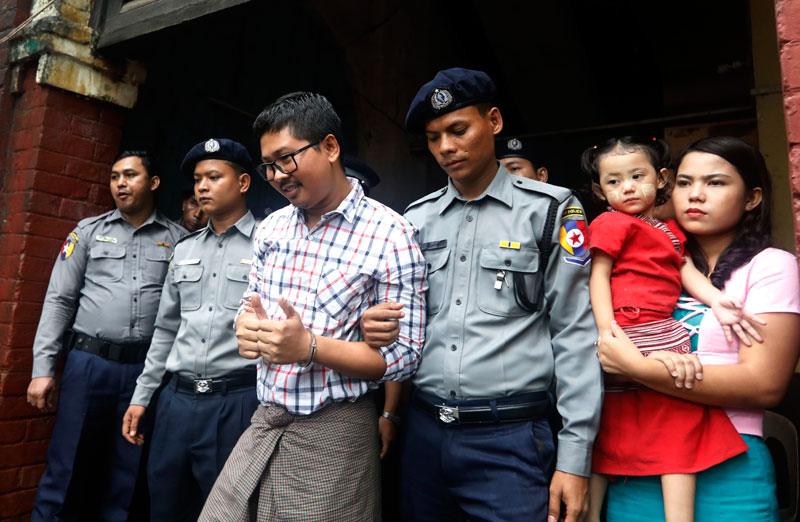 Detained Reuters journalist Wa Lone (C), 31, is escorted by police as he leaves the court after the final argument of his trial in Yangon, Myanmar, 20 August 2018. Photo: Nyeini Chan Naing/EPA