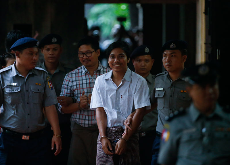 Detained Reuters journalist Kyaw Soe Oo (C), 28, is escorted by police as he arrives for the final argument of his trial at the court in Yangon, Myanmar, 20 August 2018. Photo: Lynn Bo Bo/EPA