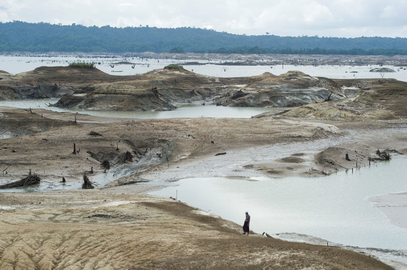 A man walks over the dried ground of the Swar Chaung dam after water level decreased when the spillway collapsed at Swar township, Bago region on August 30, 2018. Photo: Ye Aung Thu/AFP