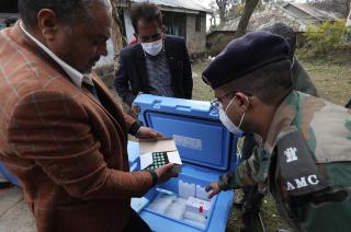 Indian officials check boxes containing Covid-19 vaccines after it arrived from Serum Institute of India at a vaccine storage centre in Dharamsala, India, 15 January 2021. Photo: EPA