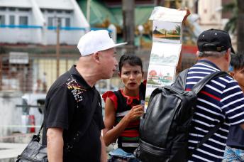 A Myanmar woman sells postcards to Chinese tourists at the Maha Bandoola park in Yangon, Myanmar. Photo: Nyein Chan Naing/EPA