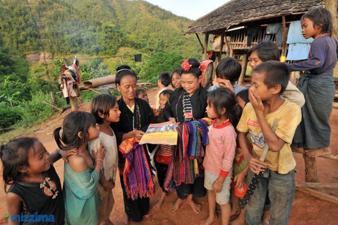 Women and children from Holan village in Kengtung Tonwship, in the east of Shan State, scan a pamphlet distributed by the Democratic Party (Myanmar) in 2010. Photo: Mizzima