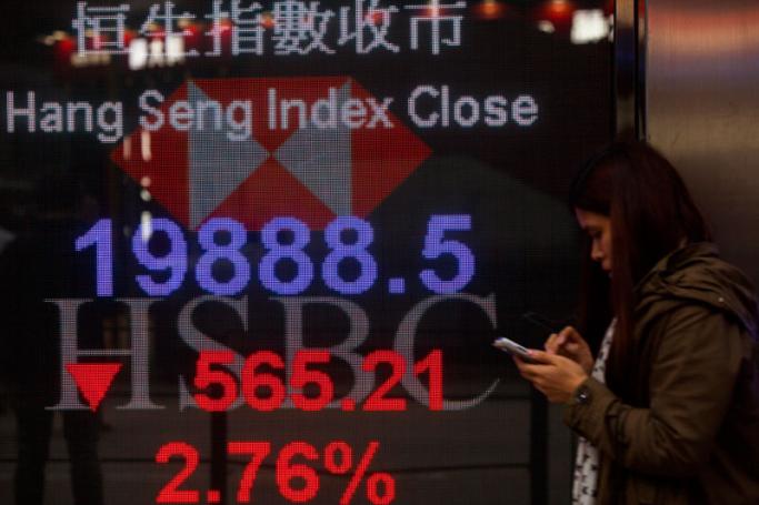 A person walks past a sign board displaying the closing numbers of the Hang Seng Index, which fell by 565.21 points, or 2.78 percent lower, to finish the day at 19,888.5, in Hong Kong, China, 11 January 2016. Photo: Alex Hofford/EPA