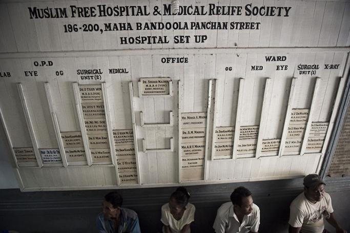 People wait at the front entrance of the Muslim free hospital in Yangon.Photo: AFP