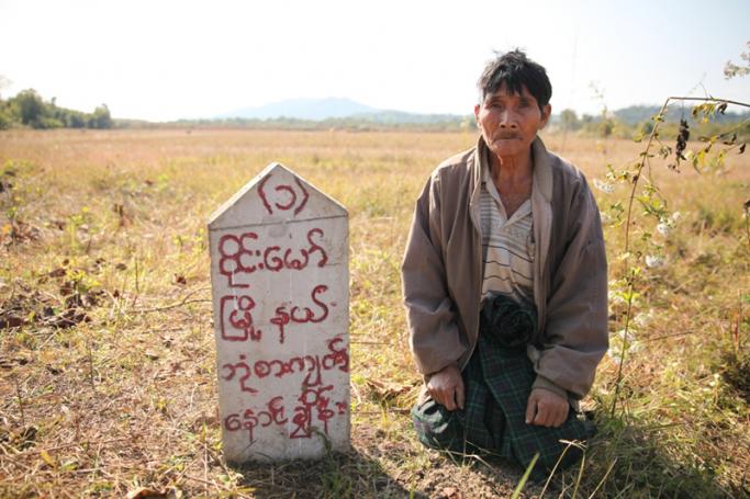 A Kachin farmer in Wai Maw township in Kachin State kneeling down on a plot of land confiscated from him by a company. (Photo: Thin Lei Win/Myanmar Now)