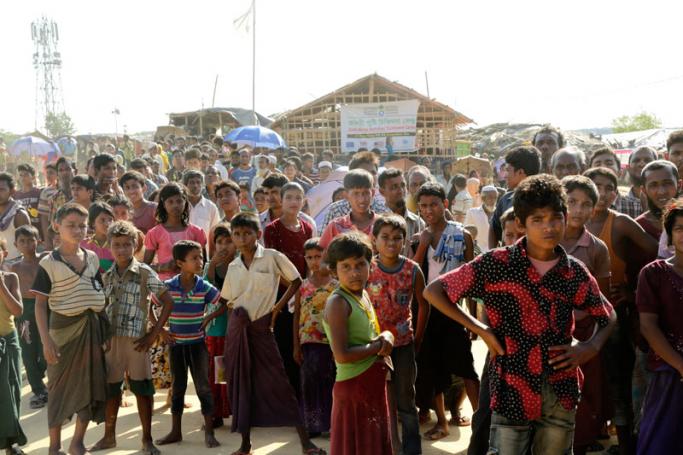 Rohingya refugee watch as the High Representative of the European Union for Foreign Affairs and Security Policy Federica Mogherini and the Minister for Foreign Affairs of Sweden Margot Wallstroem (both not pictured) visit Rohngya refugee camp at Kutupalong, Coxabazar in Bangladesh 19 November 2017. Photo: Abir Abdullah/EPA-EFE