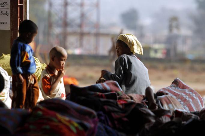 Refugees from northern Myanmar sit on a pile of blankets inside a monastery which has been set up as temporary refugee camp in KyaukMe, northern Shan State, Myanmar, 21 February 2016. Photo: Hein Htet/EPA