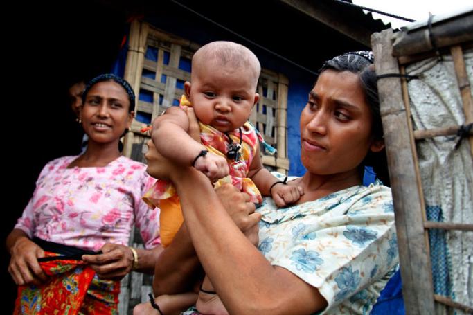 A Rohingya woman holds her child in ThetKelPyin Muslim refugee camp in Sittwe, Rakhine State 25 May 2015. Photo: Nyunt Win/EPA