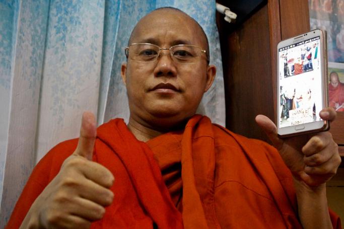 U Wirathu, holds a mobile phone while posing for photos at Masoyein monastery in Mandalay, Myanmar, 29 May 2015. Photo: Pyae Sone Aung/EPA