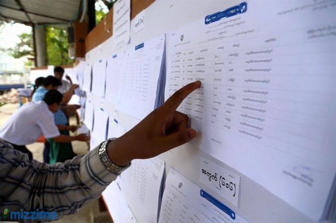 People check their names on voters' lists in Chanaye Tharzan Township, Mandalay on 14 September, 2015. Photo: Bo Bo/Mizzima