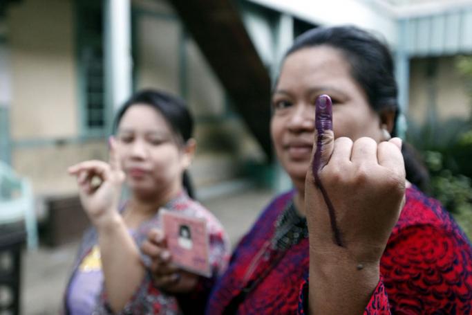 Myanmar women voters show their ink marked finger after casting their votes at a polling station in Mandalay, Myanmar, 08 November 2015. Photo: Hein Htet/EPA