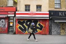 A man walks past closed shops in east London, Britain, 15 January 2021. Photo: EPA
