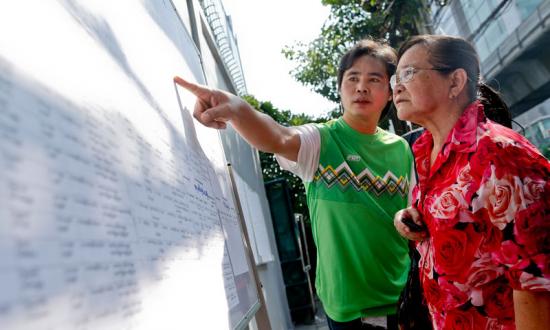 Myanmar nationals search for their names on lists outside the Myanmar Embassy as they wait for their turn to vote early, in Bangkok, Thailand, 17 October 2015. Photo: Diego Azubel/EPA